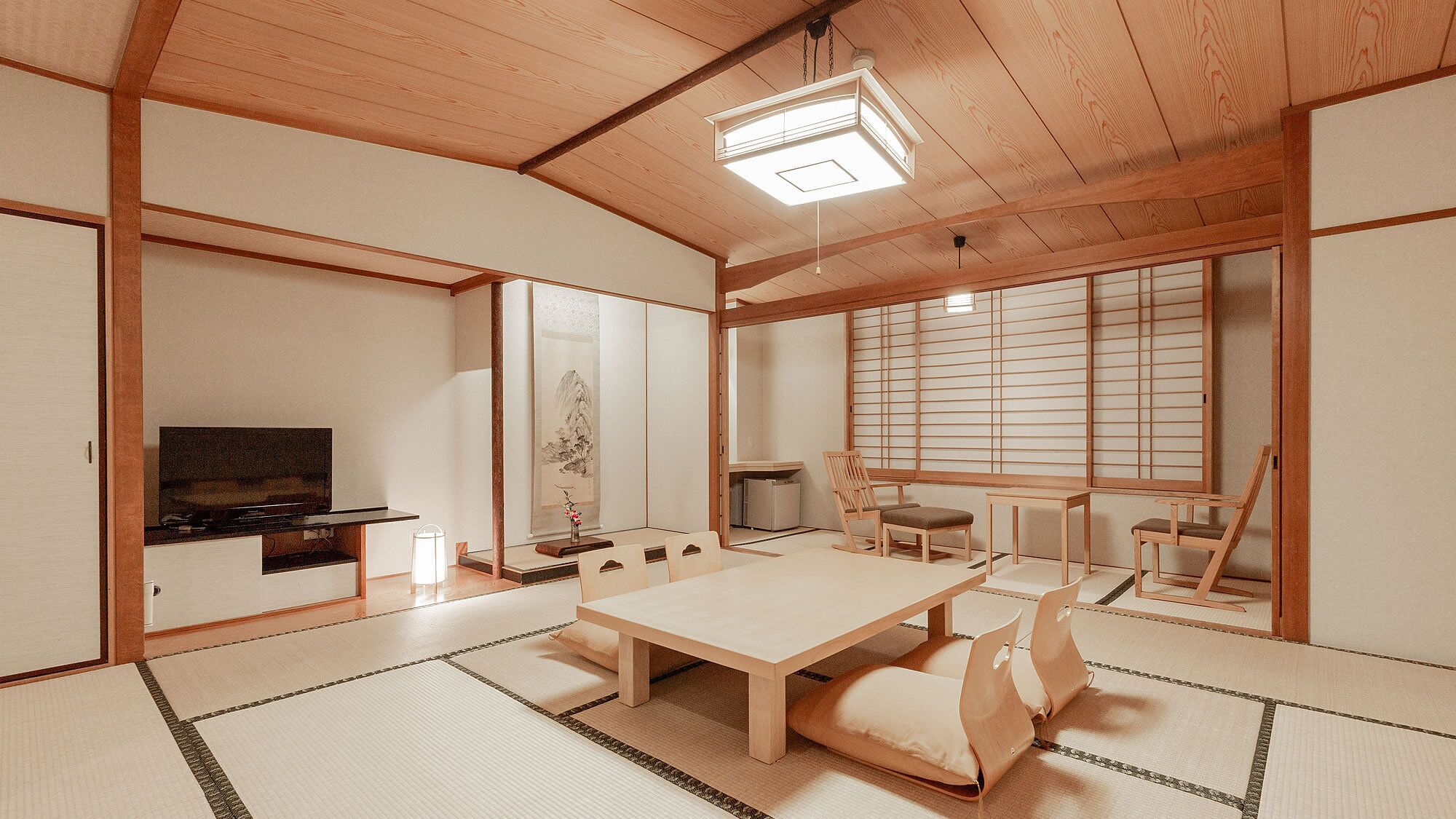 Une pièce de style japonais traditionnel, avec un sol recouvert de tatamis, une table basse et des portes coulissantes.