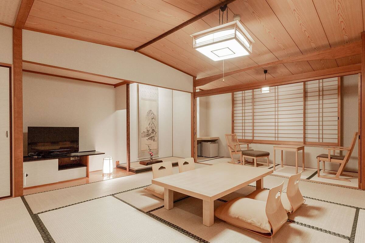 Une pièce de style japonais traditionnel, avec un sol recouvert de tatamis, une table basse et des portes coulissantes.