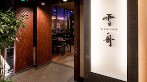 A restaurant interior with a wooden wall, a counter, and a sign with foreign script. - Yudaonsen Ubl Hotel Matsumasa (Yamaguchi)