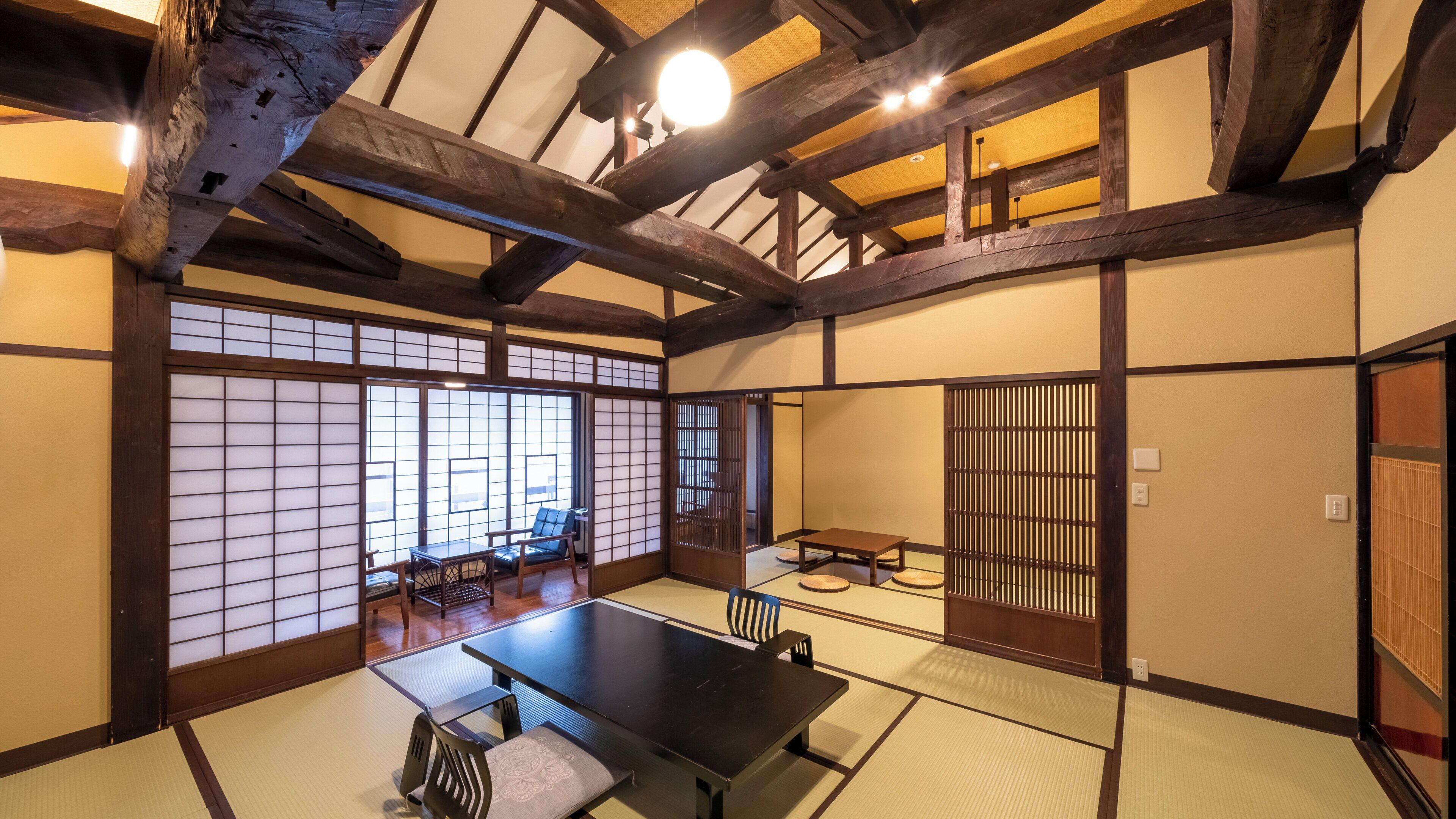 A traditional Japanese room with tatami flooring, a low table, and sliding doors.