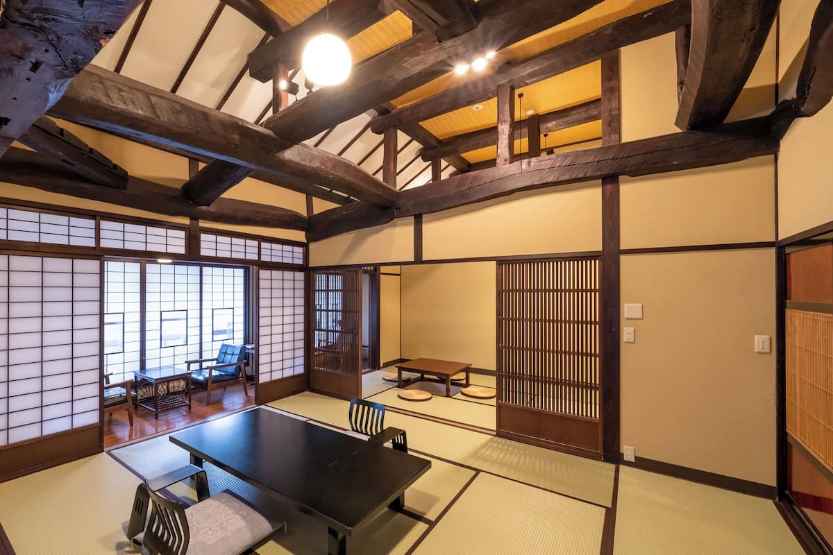 A traditional Japanese room with tatami flooring, a low table, and sliding doors.