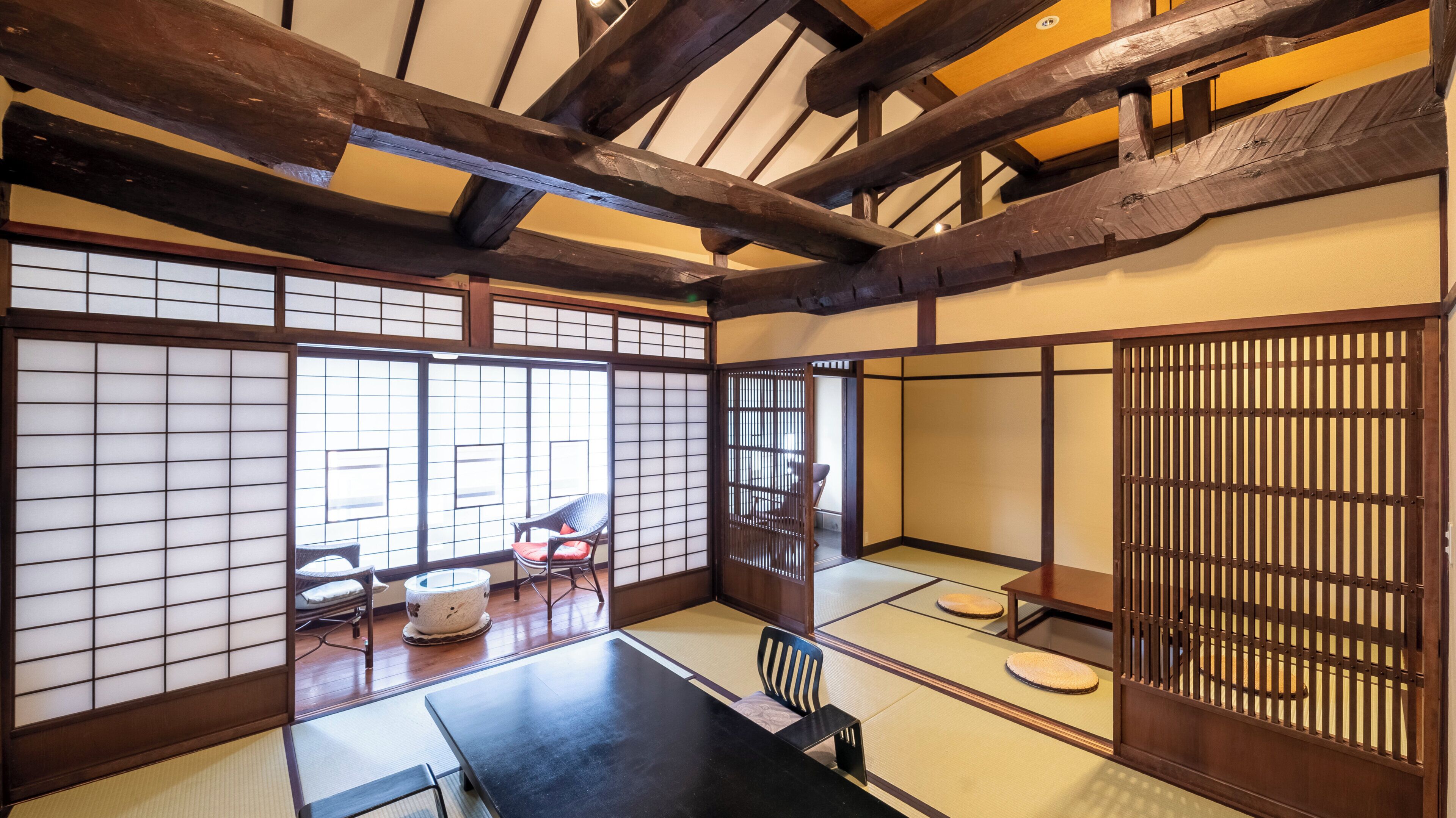 A traditional Japanese room with tatami flooring, a low table, and sliding doors.