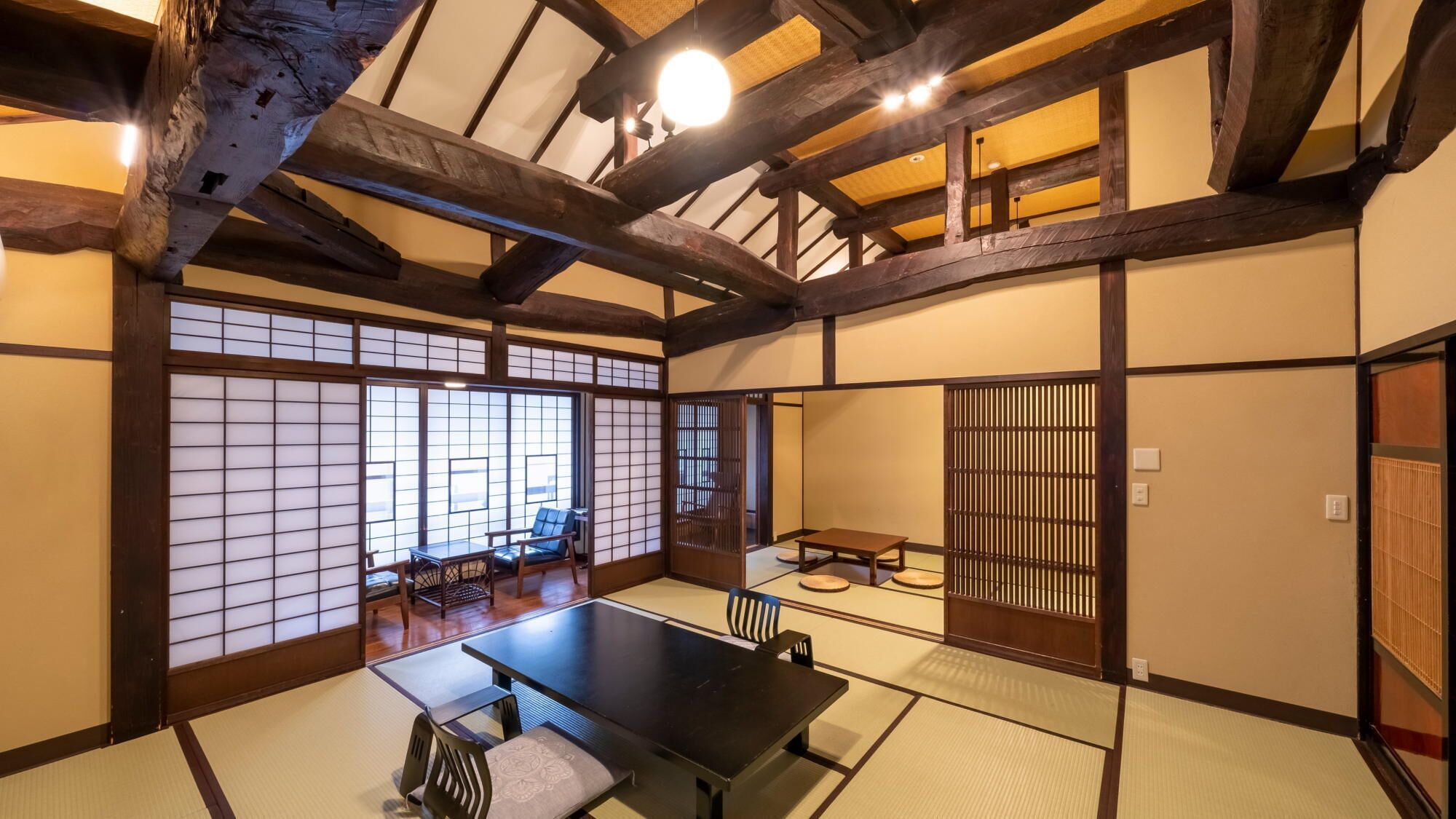 Una habitación japonesa tradicional con suelo de tatami, una mesa baja y una puerta corredera.