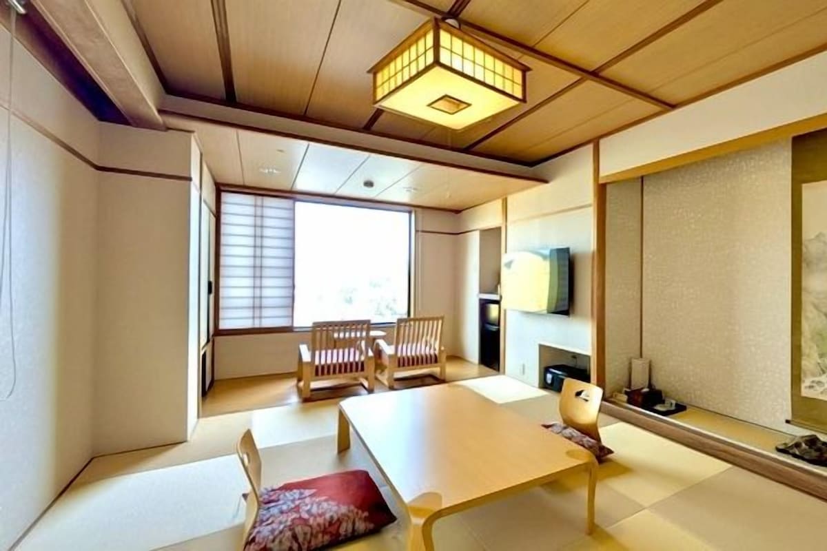 A traditional Japanese room with tatami flooring, a low table, and sliding doors.