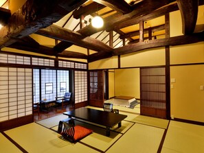 A traditional Japanese room with tatami flooring, a low table, and sliding doors. - Ryokan Nakamatsuya (Nagano)