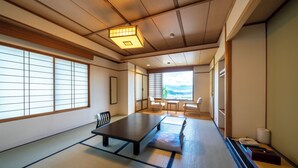 A traditional Japanese room with tatami flooring, a low table, and sliding doors. - Ryokan Nakamatsuya (Nagano)