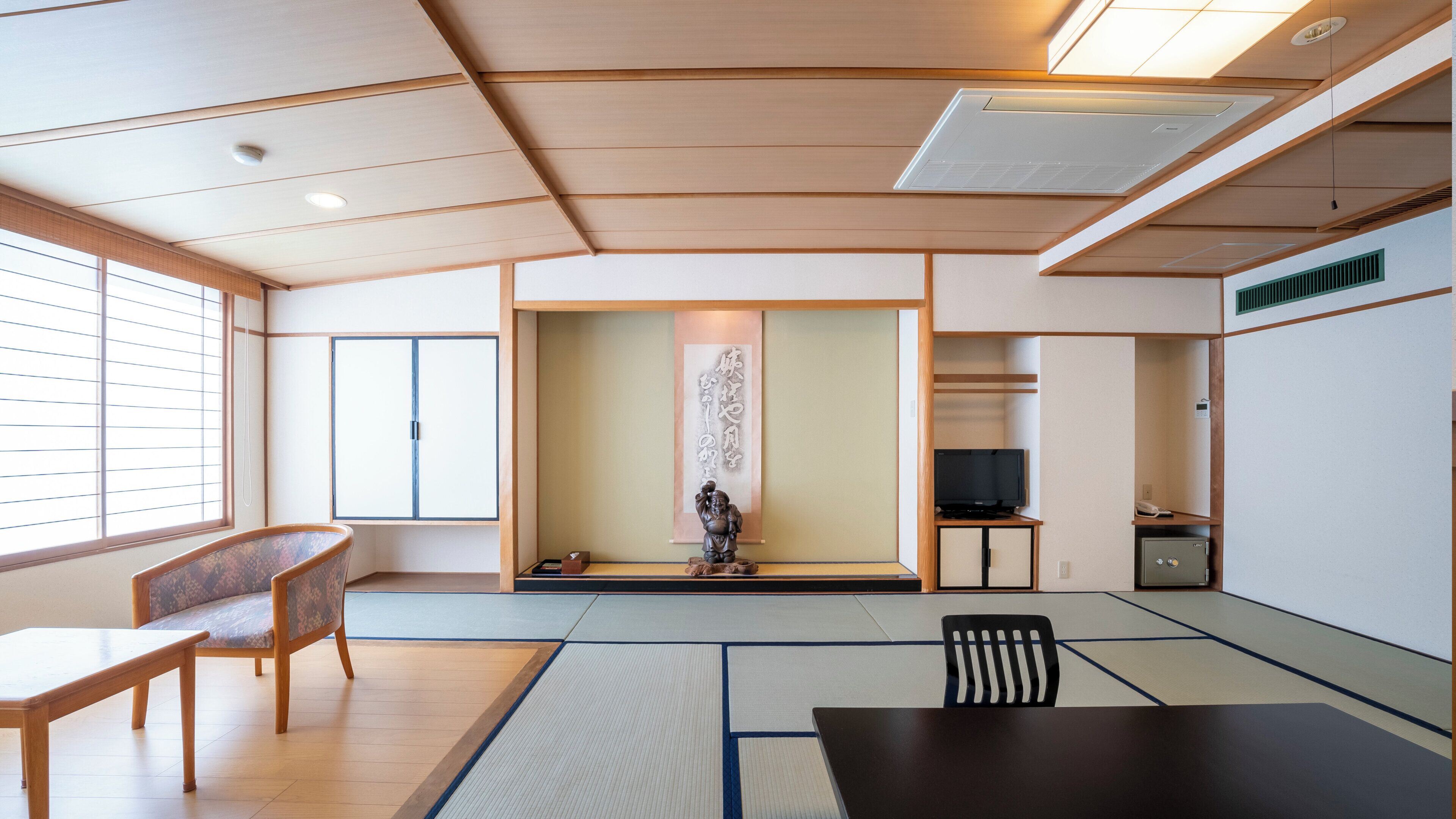 A traditional Japanese room with tatami flooring, a low table, a chair, a television, and a cabinet.