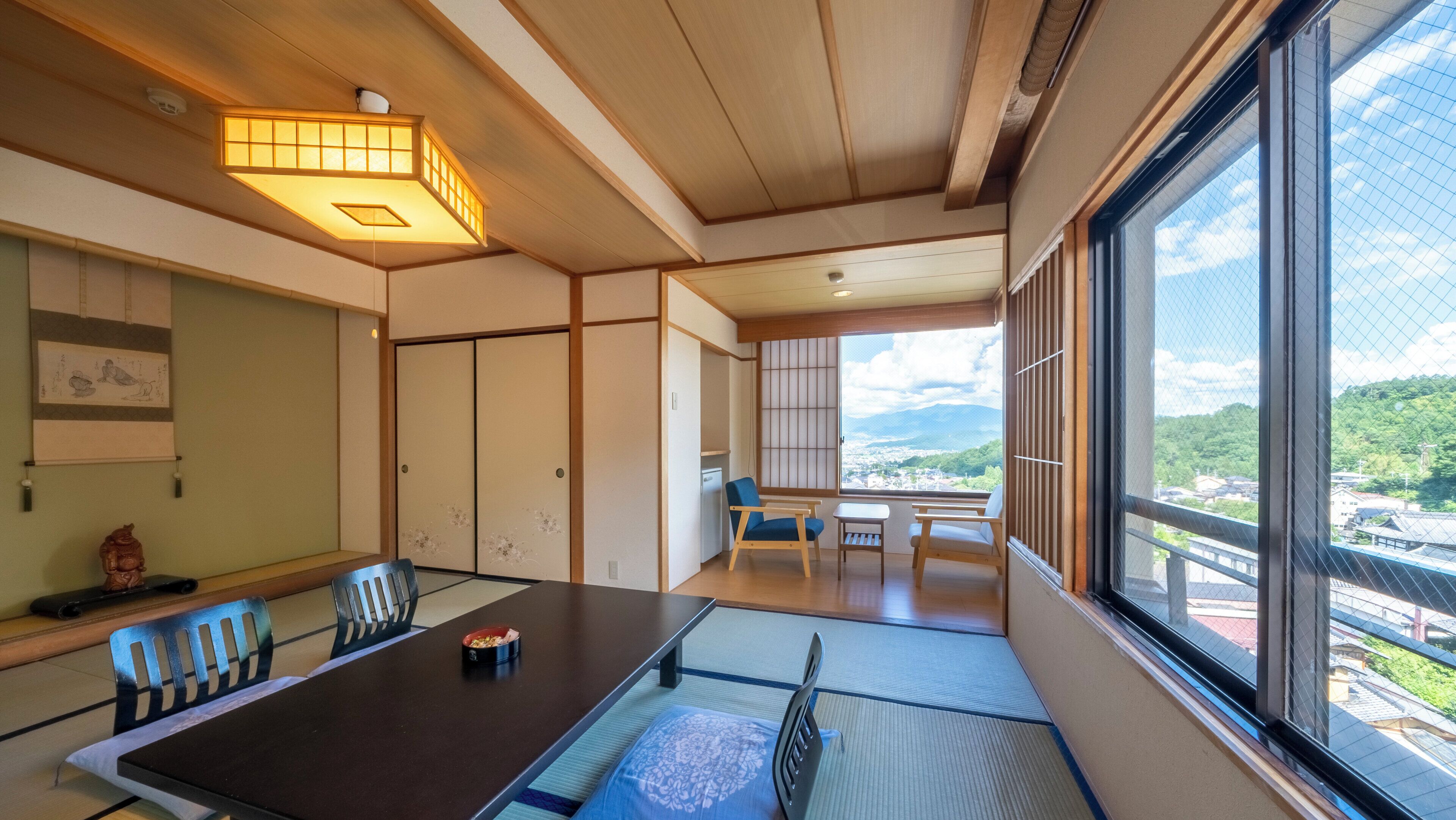 A traditional Japanese room with tatami flooring, a low table, and sliding doors.