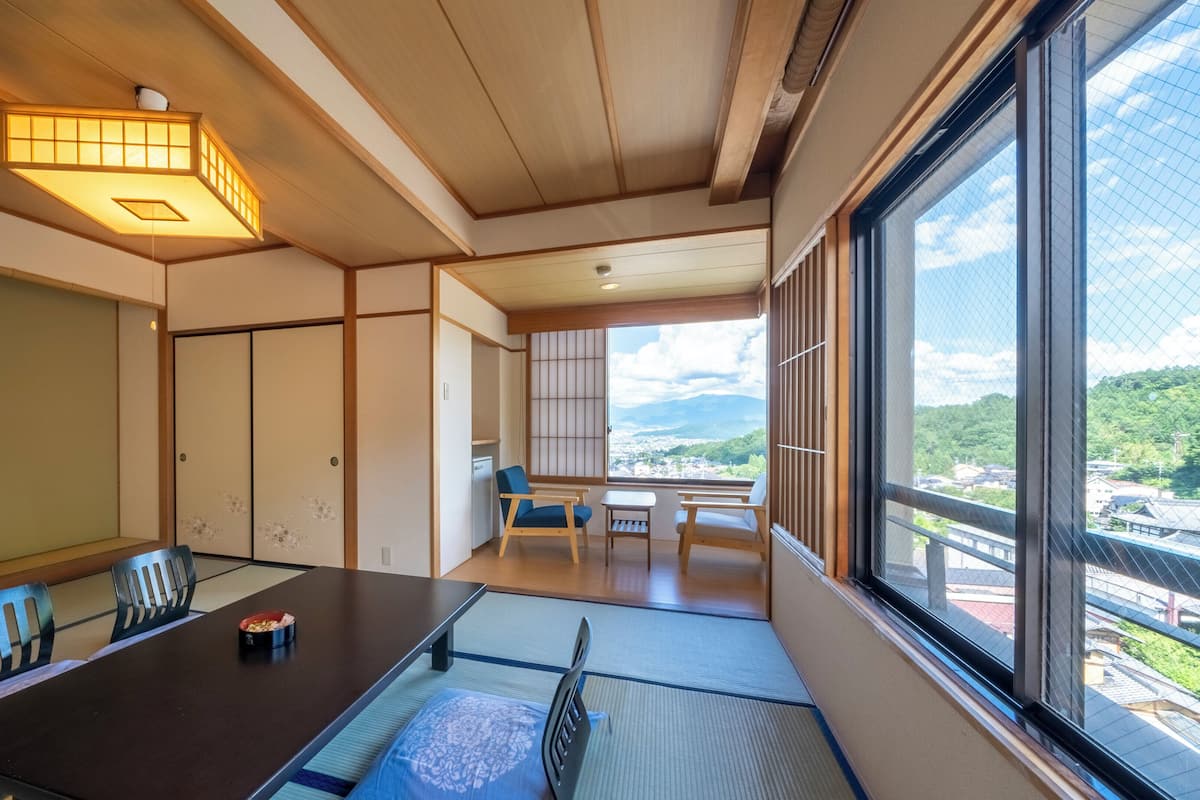 A traditional Japanese room with tatami flooring, a low table, and sliding doors.