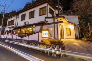 Un edificio de dos plantas con un estilo arquitectónico tradicional, que presenta una entrada destacada con un letrero iluminado.