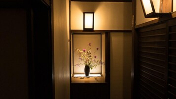 Un pasillo con una ventana que presenta un jarrón de flores.