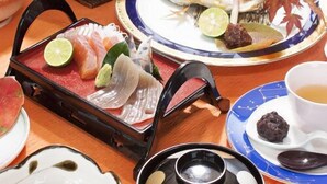 A dining table with various dishes, including sashimi, a hot pot, and a cup of tea. - Tsukinoyado (Kamikatsu)