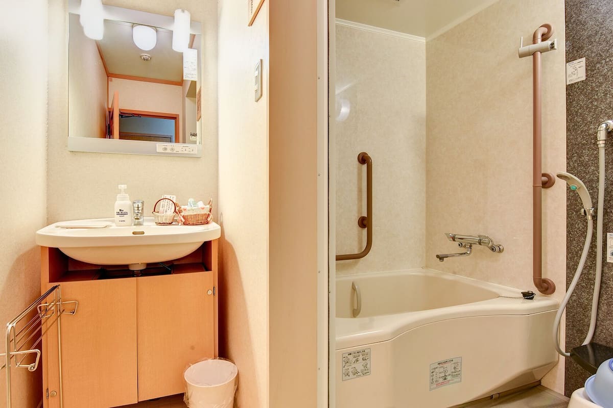 Une salle de bain avec un lavabo, un miroir et une douche.