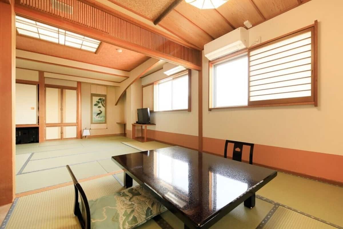 Ein traditioneller japanischer Raum mit Tatami-Boden, einem niedrigen Tisch und Schiebetüren.