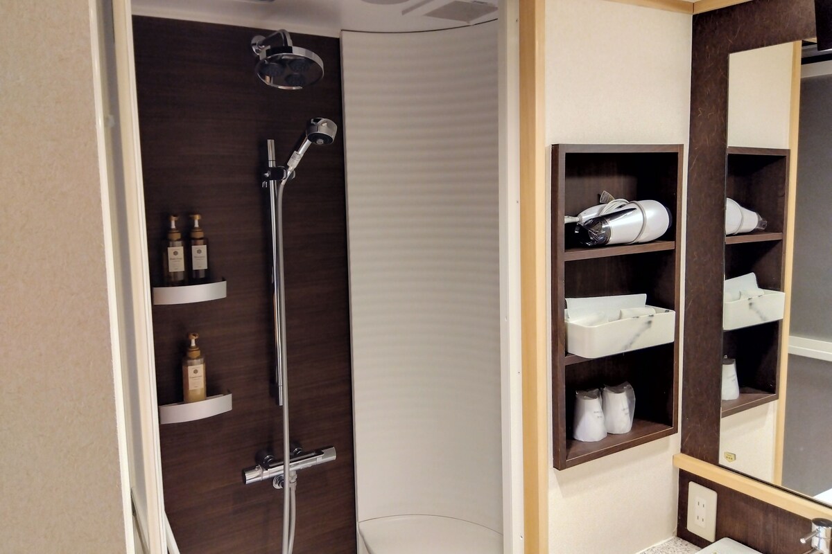 Ein modernes Badezimmer mit Dusche, integrierten Ablagen und einem Spiegel.