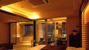 A modern hotel room with a bed, a desk, and a glass door leading to a balcony. - Fuji Kawaguchiko Onsen Lakeland Hotel Mizunosato (Fujikawaguchiko)