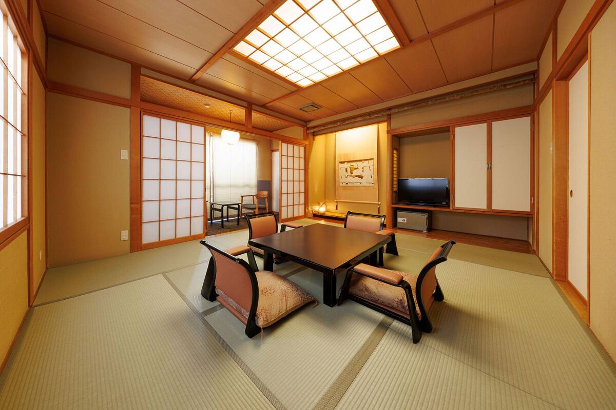 Ein traditioneller japanischer Raum mit Tatami-Böden, einem niedrigen Tisch und Shoji-Bildschirmen.