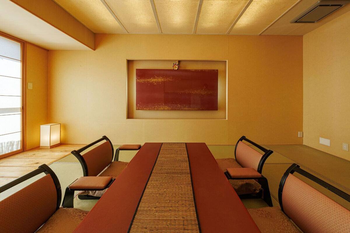 Ein Konferenzraum mit einem langen Tisch, sechs Stühlen und einem großen, abstrakten Gemälde an der Wand.