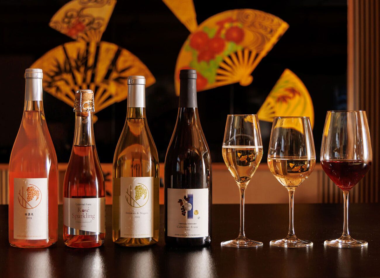 A selection of wine bottles and glasses on a table.