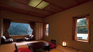 Una habitación tradicional con tatami, una mesa baja, sillas y un farol.