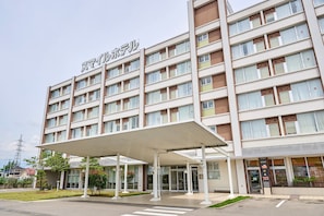 A multi-story hotel with a covered entrance and a sign indicating it is a hotel.