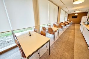 A conference room with tables and chairs, large windows, and a carpeted floor. - Smile Hotel Shirakawa (Nishigo)