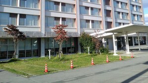 A multi-story hotel building with a sign indicating it is a hotel. - Smile Hotel Shirakawa (Nishigo)