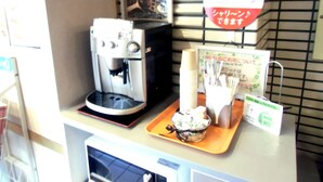A coffee machine, a tray with a bowl of food, and a sign with Japanese text. - Hotel Green Pacific (Sendai)