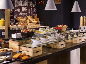 A breakfast buffet with various food items and condiments. - Ibis London Wembley (London)