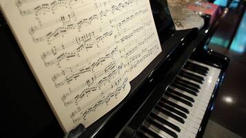 Un piano avec des partitions sur son pupitre.