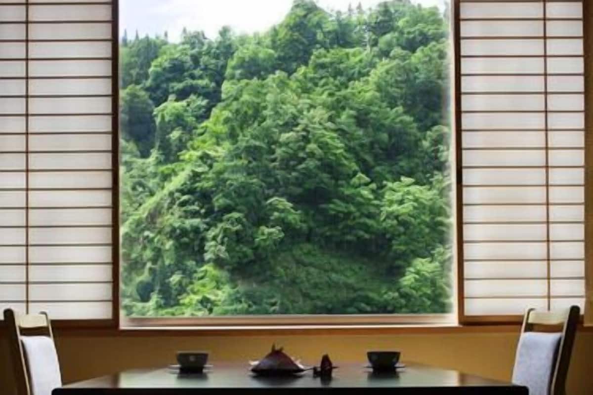 Ein traditioneller japanischer Raum mit Tatami-Böden, einem niedrigen Tisch und Shoji-Schirmen.