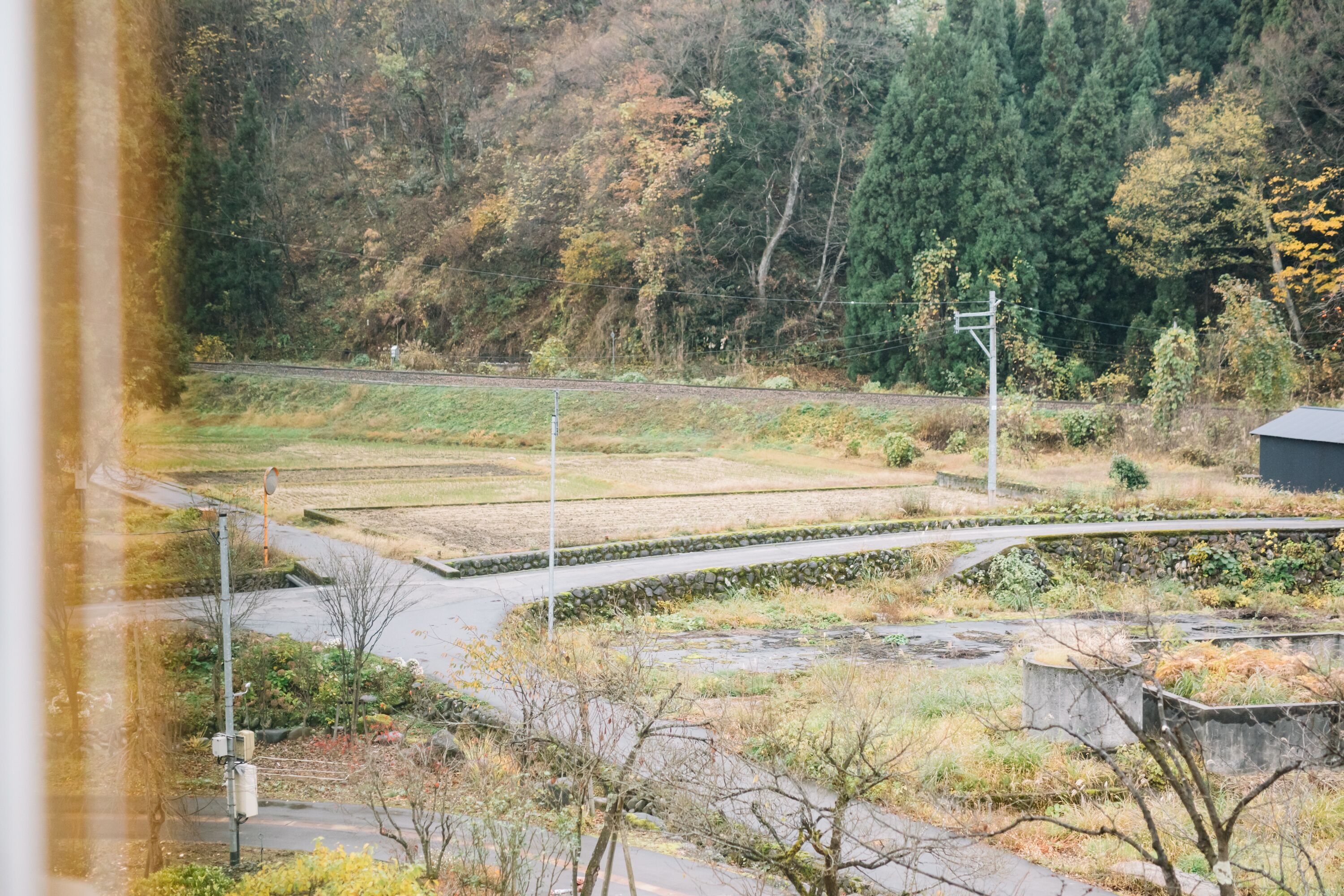 A view of a railway track with a curve, surrounded by greenery and trees.