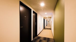 A hotel hallway with carpeted floors, black doors, and recessed lighting. - Hotel Sunroute Sukagawa (Sukagawa)