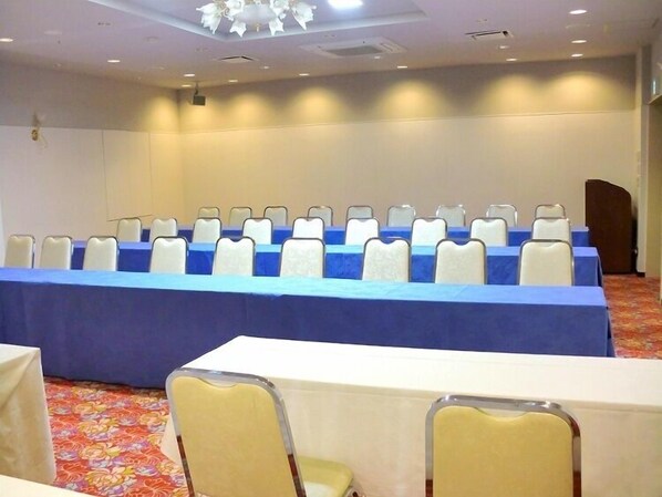 A conference room with a long table, rows of chairs, and a carpeted floor. - Hotel Sunroute Sukagawa (Sukagawa)