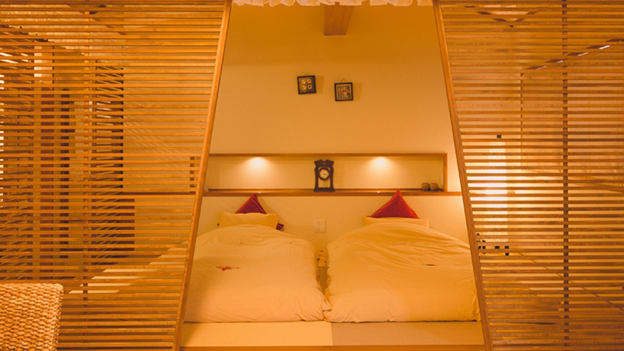 Ein Zimmer mit einem Bett, einer Uhr und zwei gerahmten Bildern an der Wand.