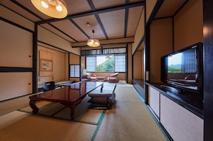 A traditional Japanese-style room with tatami flooring, a low table, and a television.