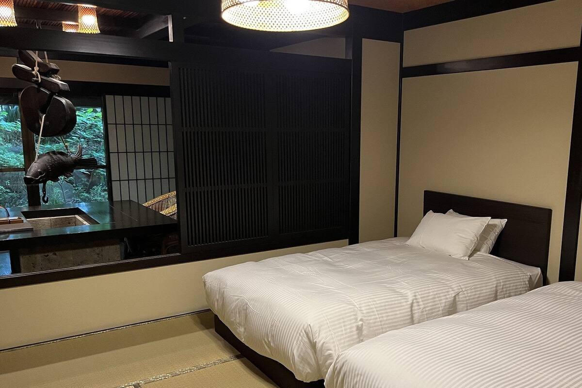 Ein Hotelzimmer mit zwei Betten, einem großen Fenster und einer dekorativen Fischskulptur.