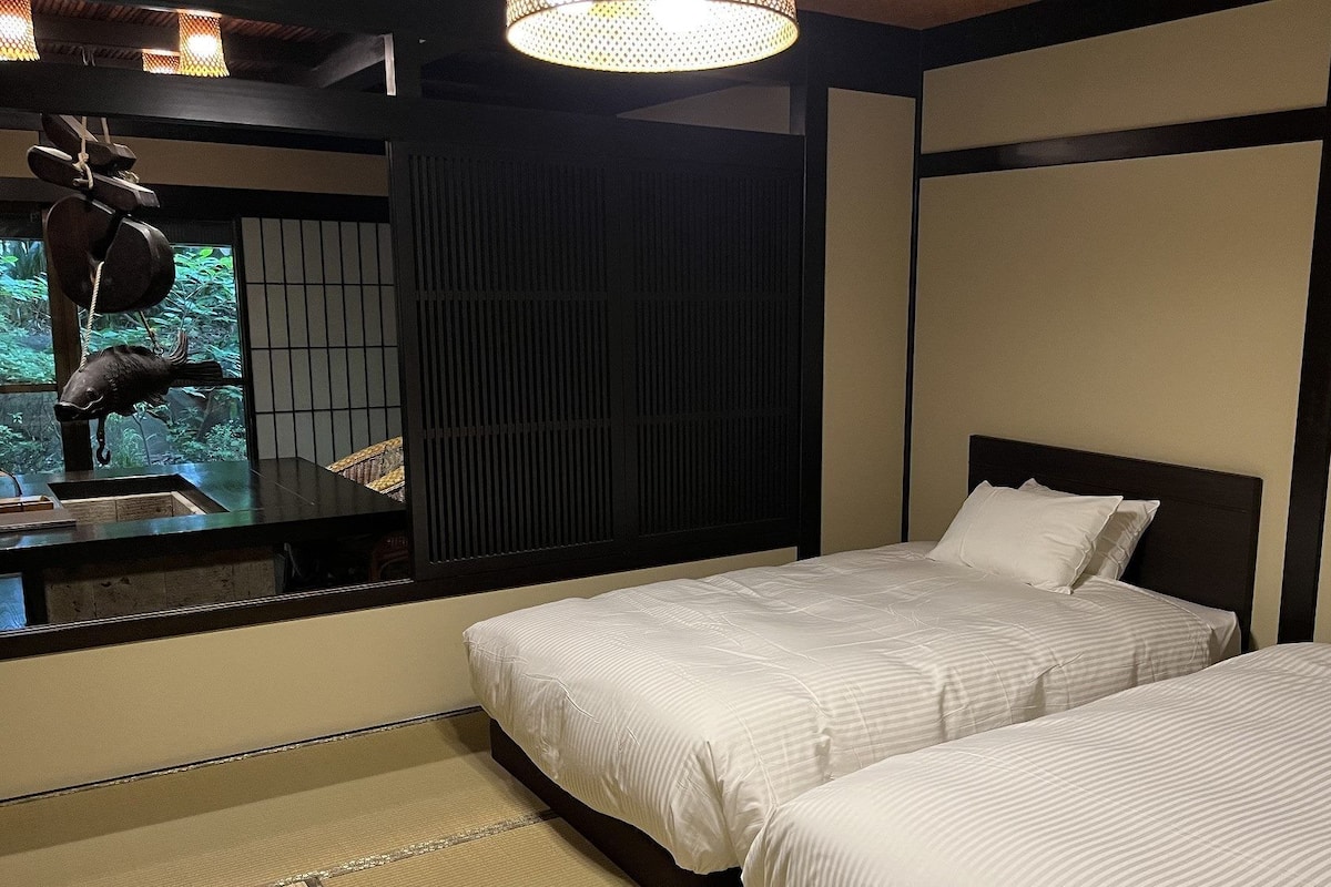 A hotel room with two beds, a large window, and a decorative fish sculpture.