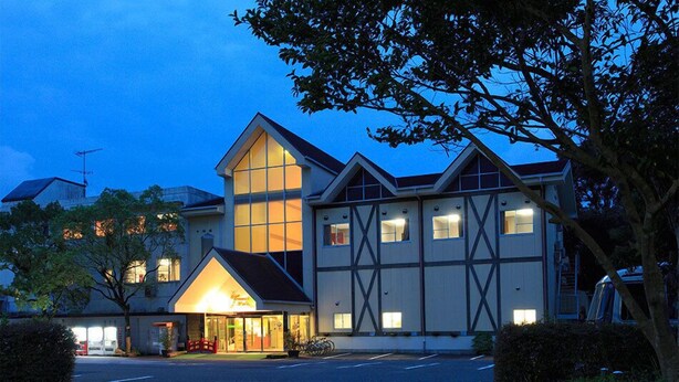 Un hotel con una entrada destacada, amplias ventanas y un diseño arquitectónico moderno.
