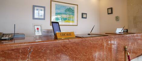 A marble reception desk with a sign reading "FRONT".