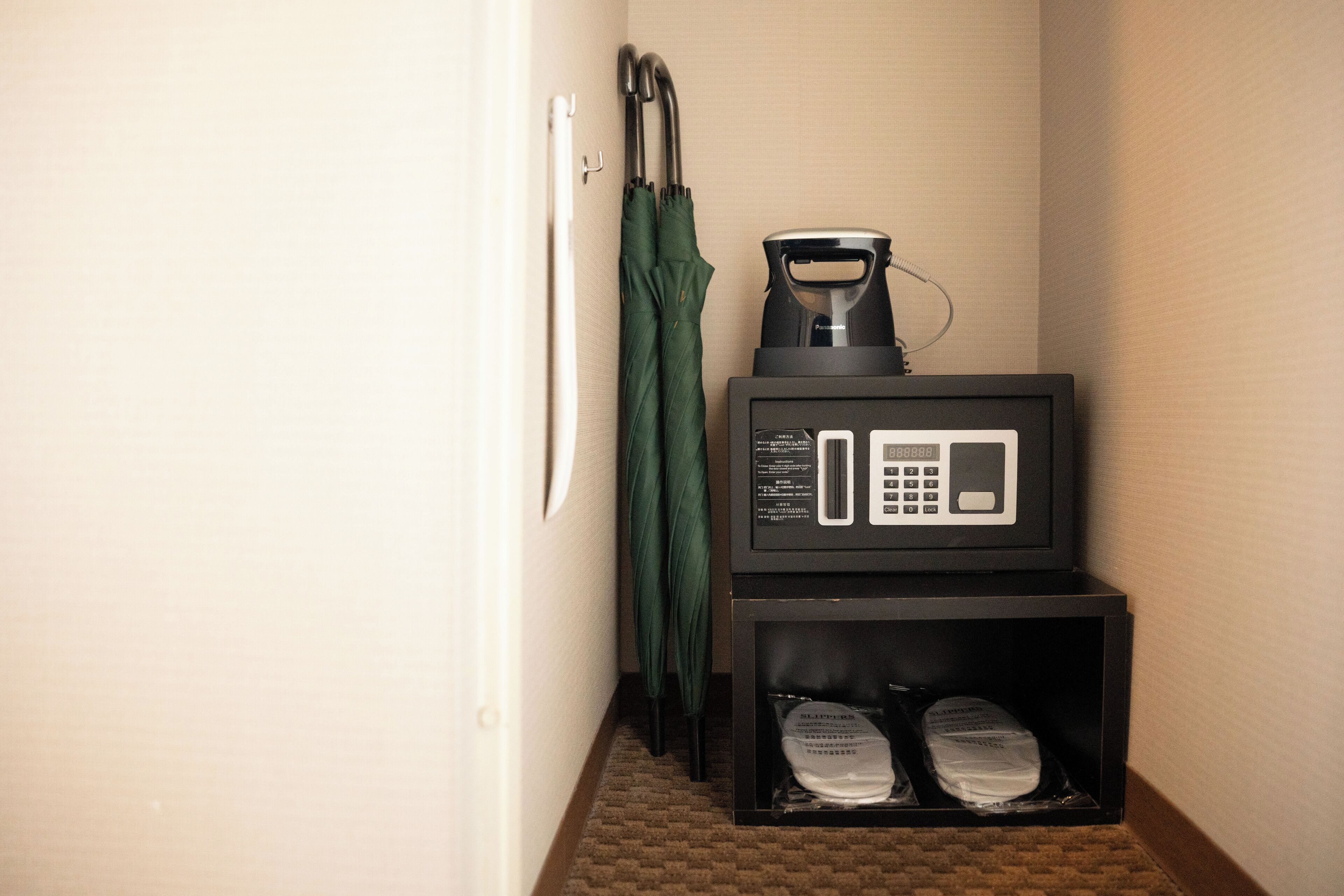 A microwave and a coffee maker on a black countertop in a hotel room.