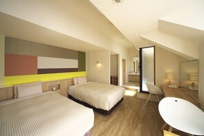 Habitación de hotel moderna con dos camas, un escritorio y un espejo grande.