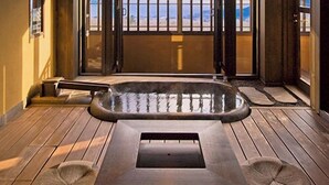 Un jacuzzi con terraza de madera, vistas al mar y un balcón con barandilla.