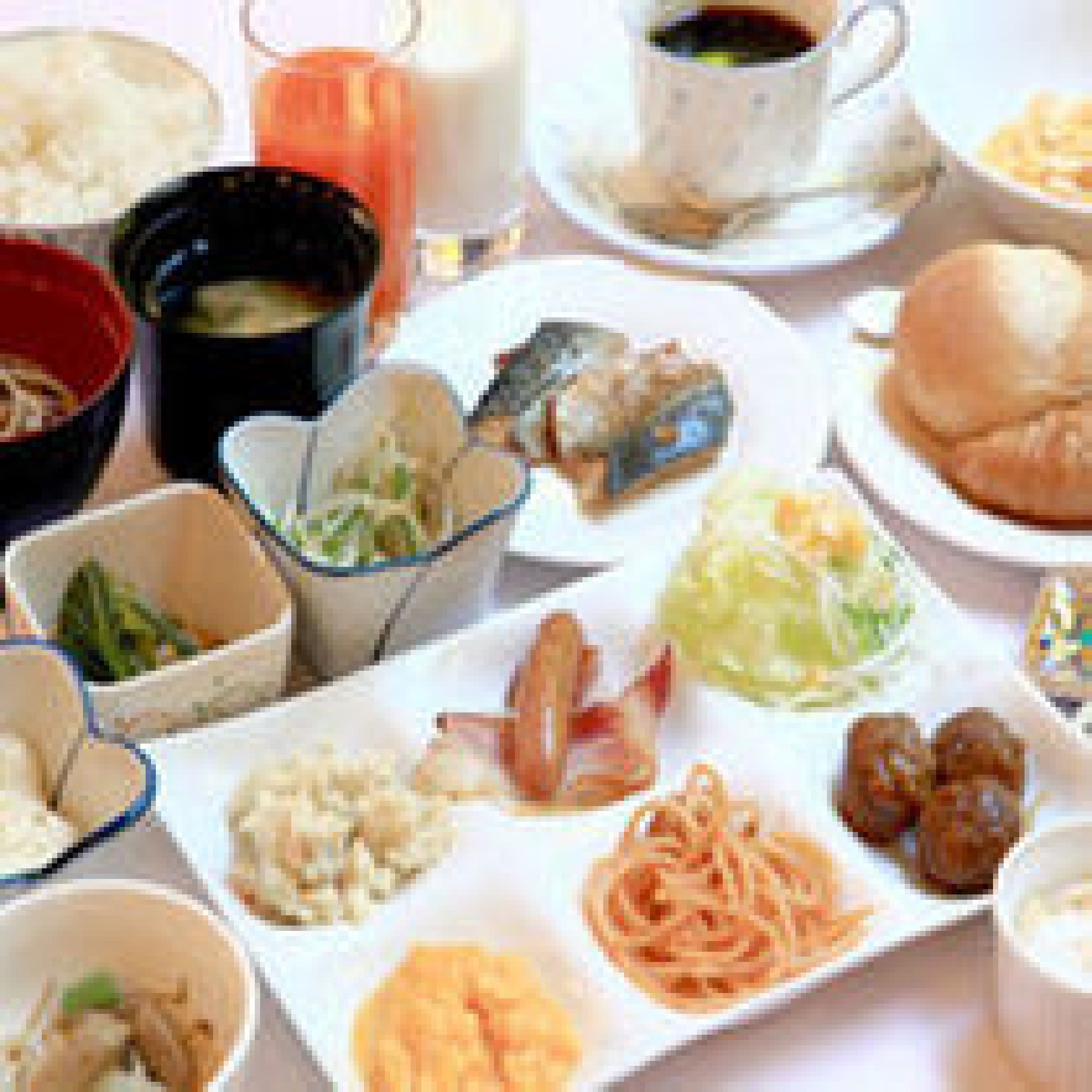 Una mesa con diferentes platos, incluyendo fideos, dumplings y un tazón de sopa.
