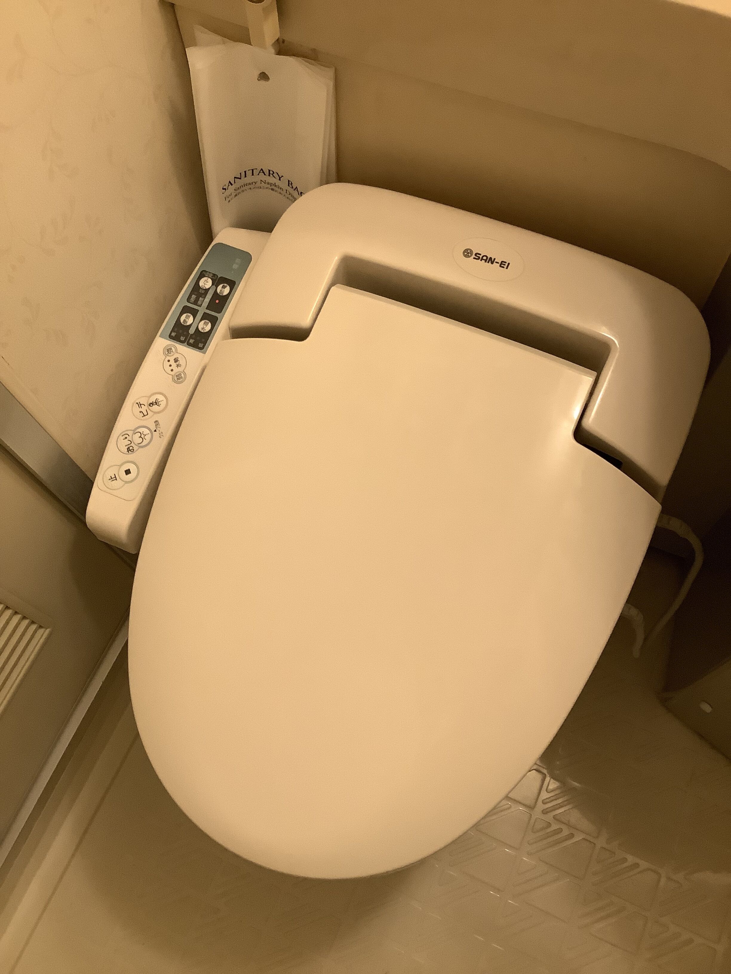 A modern toilet with a control panel featuring buttons and a digital display.