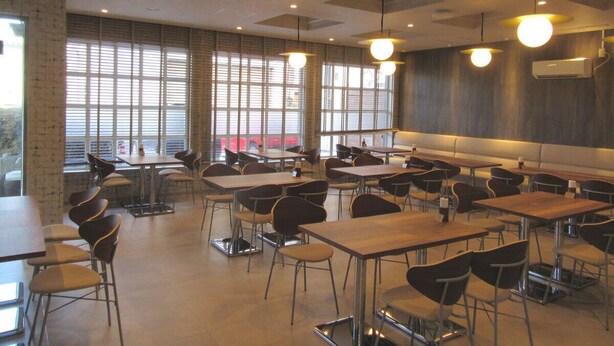 A classroom with tables and chairs, large windows, and ceiling lights. - Smile Hotel Hachinohe (Hachinohe)