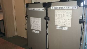Two portable toilets with instructions and a sign indicating they are for use by guests.