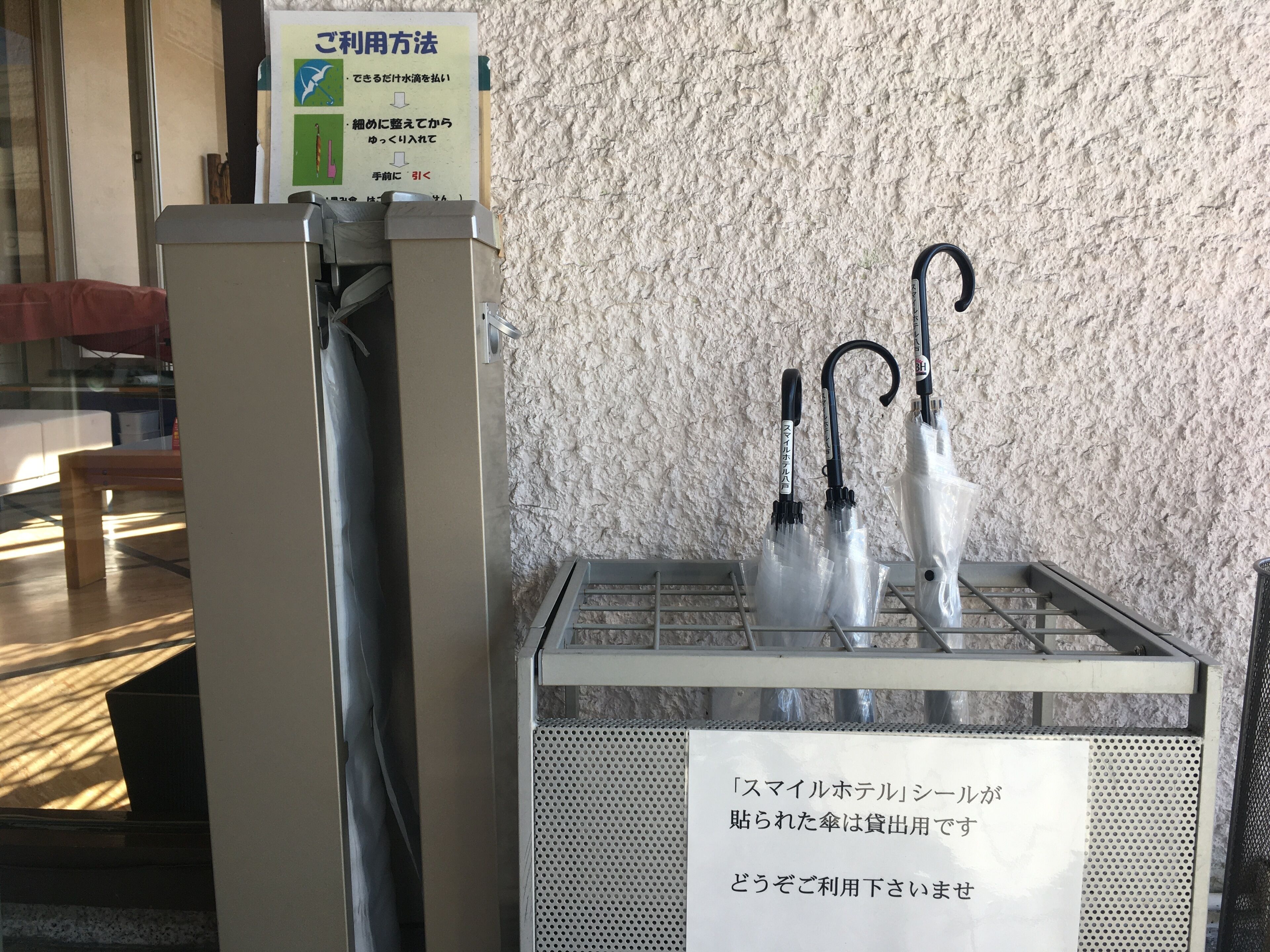 A metal rack with umbrellas and a sign indicating the use of a mobile hotel service.