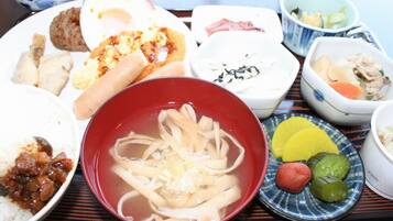 A variety of Japanese dishes on a tray, including rice, noodles, and several small bowls with different sauces and sides.