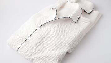 A neatly folded white shirt with a black collar and cuffs.